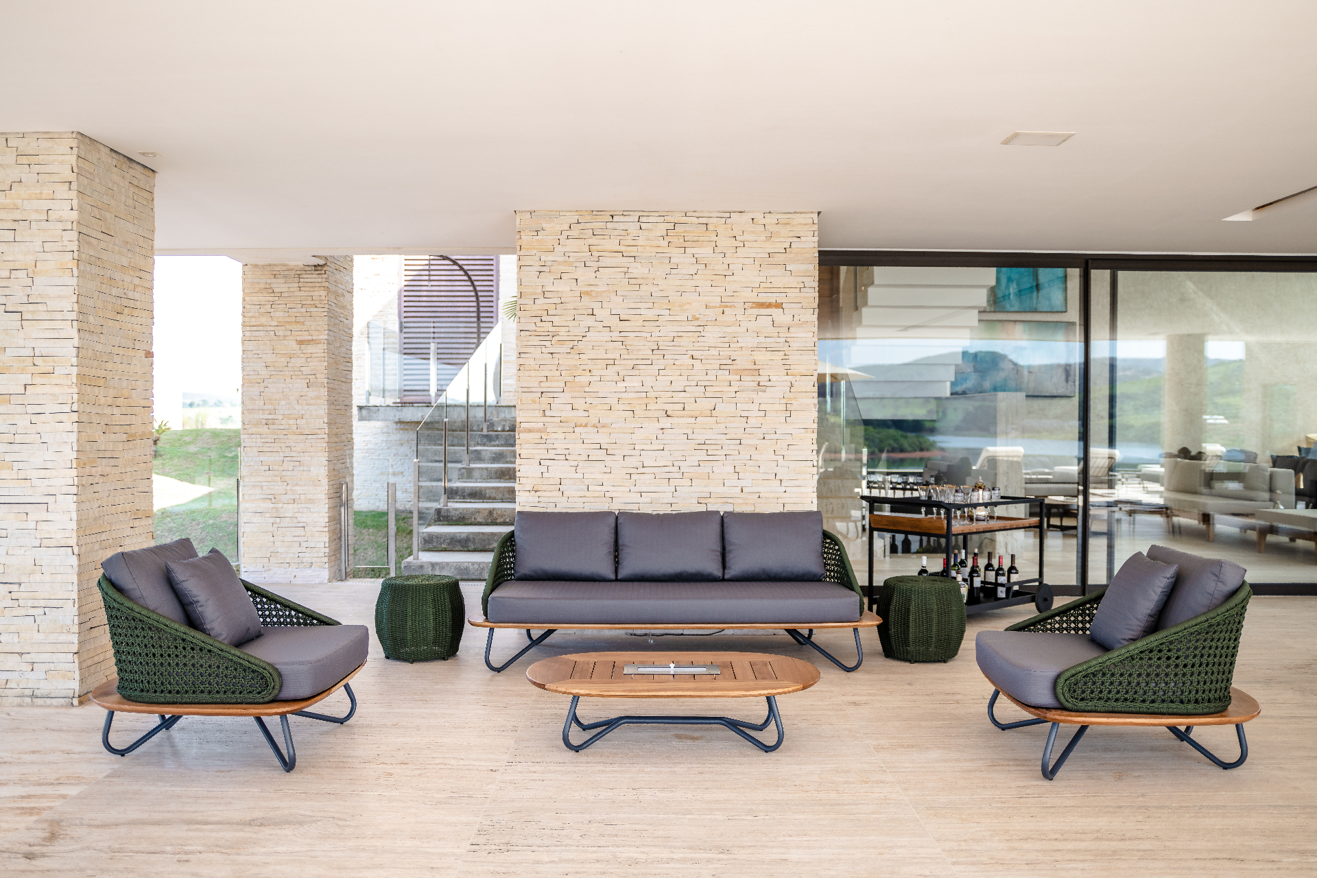 Sofá e poltronas em corda verde em sala integrada com vista